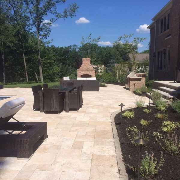 Outdoor patio with a masonry fireplace, seating area and planted beds