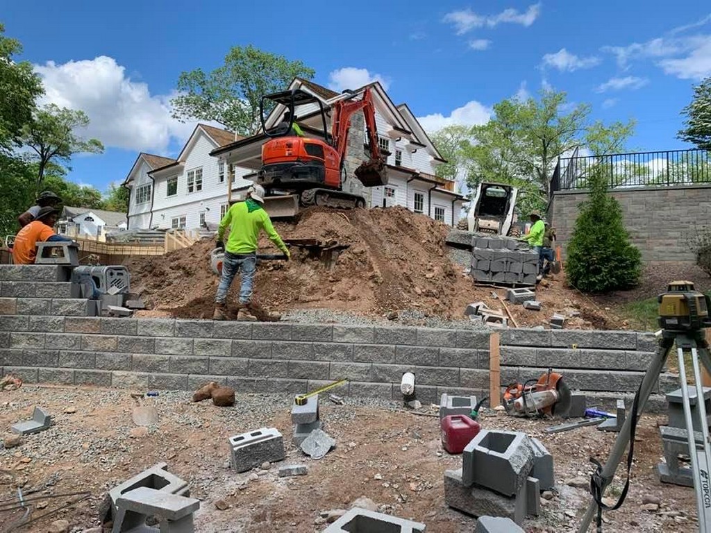 JLJ Construction crew setting block courses during a retaining wall installation